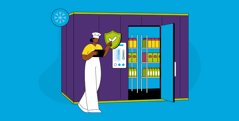 Por que o controle de temperaturas é fundamental em bares e restaurantes Funcionária conferindo câmara fria aberta com tablet e painel de medição, representando o controle de temperatura para armazenamento seguro de alimentos.